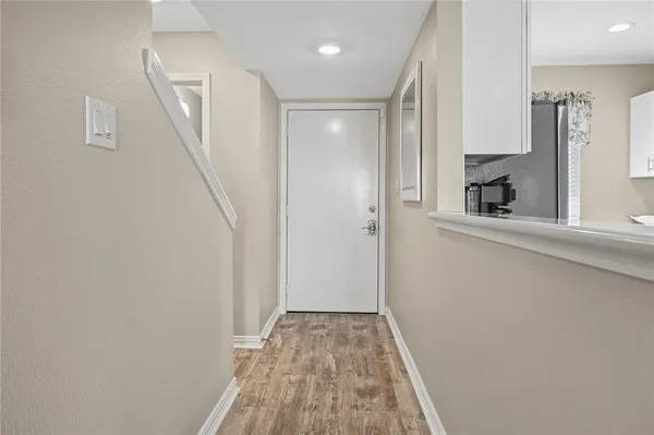 a view of a hallway with wooden floor and staircase