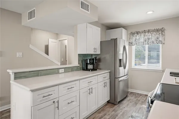 a kitchen with appliances a sink and cabinets