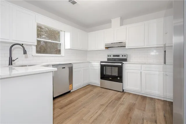 a kitchen with a stove sink and cabinets