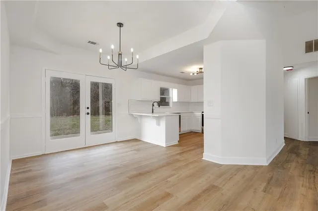 a view of a big room with wooden floor and a kitchen