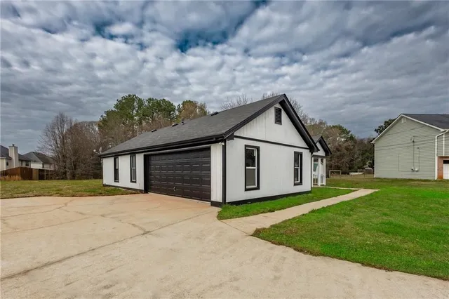 a view of a house with a yard and large tree