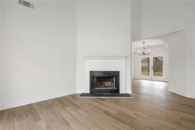 a view of empty room with wooden floor and fireplace