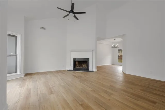 a view of empty room with wooden floor and fireplace