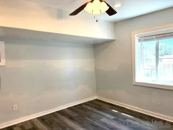 en empty room with wooden floor and windows