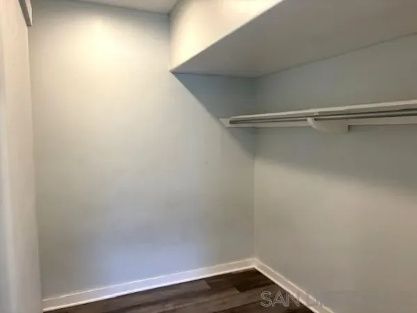 a view of a small space with wooden floor and a window