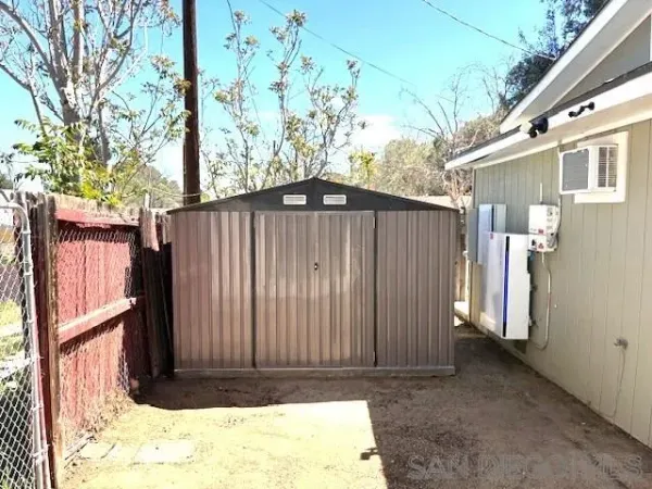 a view of a house with a wooden fence and trees