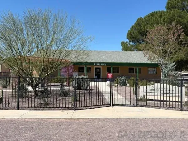 a view of a house with a wooden fence