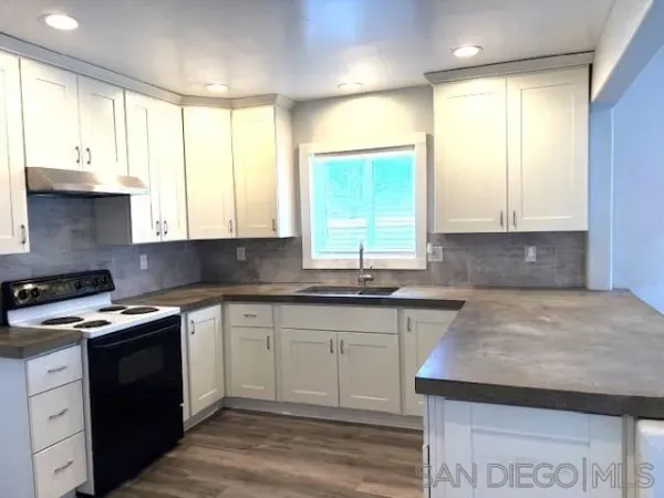 a kitchen with stainless steel appliances granite countertop wooden cabinets and a large window
