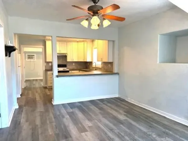 a view of a kitchen with wooden floor and a window