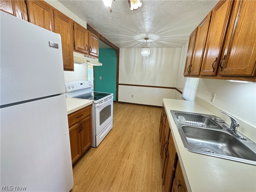 1763 Aberdeen Road Madison, OH 44057 - Photo 14 of 31 Kitchen with pendant lighting, white appliances, sink, and light hardwood / wood-style floors