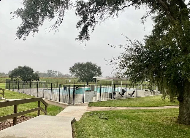 a view of yard with swimming pool and trees