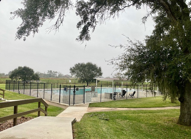 218 Cattle Drive Trail Angleton, TX 77515 - Photo 11 of 34 a view of a swimming pool with a garden and trees
