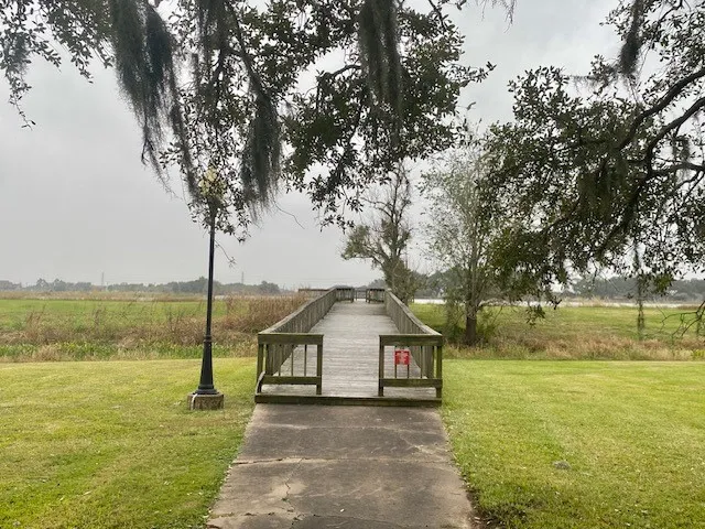 a group of people sitting on a pier next to a lake