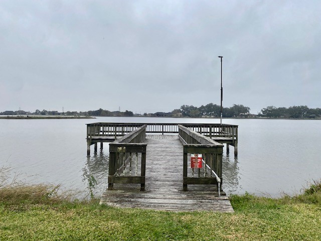 218 Cattle Drive Trail Angleton, TX 77515 - Photo 17 of 34 a group of people sitting on a pier next to a lake