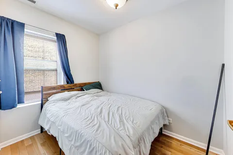 a large bed sitting in a bedroom next to a window
