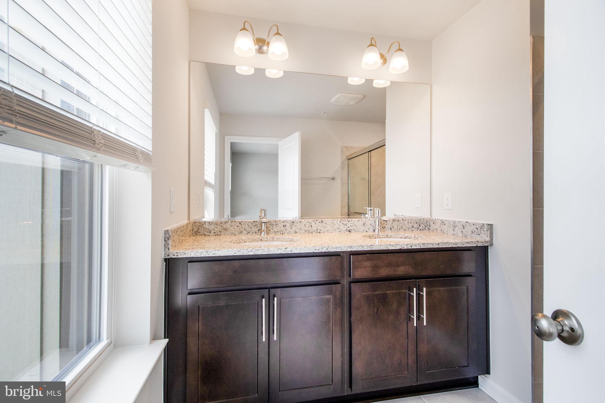 280 Ensemble Way Frederick, MD 21701 - Photo 19 of 25 a bathroom with a granite countertop sink a large mirror and a vanity
