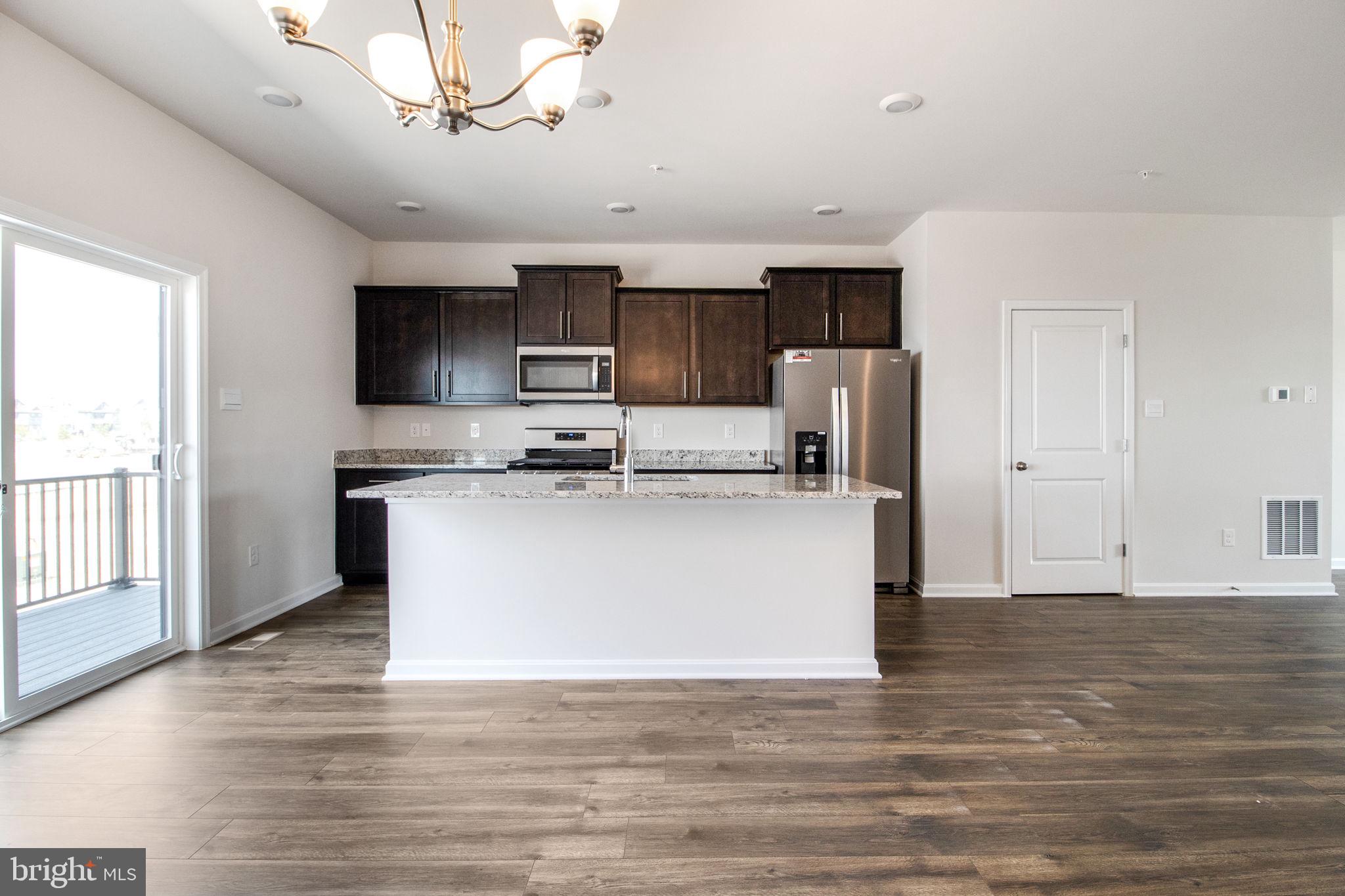 280 Ensemble Way Frederick, MD 21701 - Photo 4 of 25 a view of kitchen with stainless steel appliances granite countertop a stove top oven a refrigerator a sink and dishwasher with wooden floor