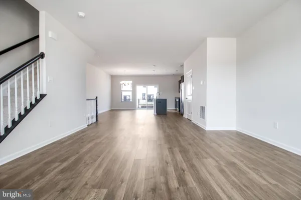 a view of a big room with wooden floor and windows