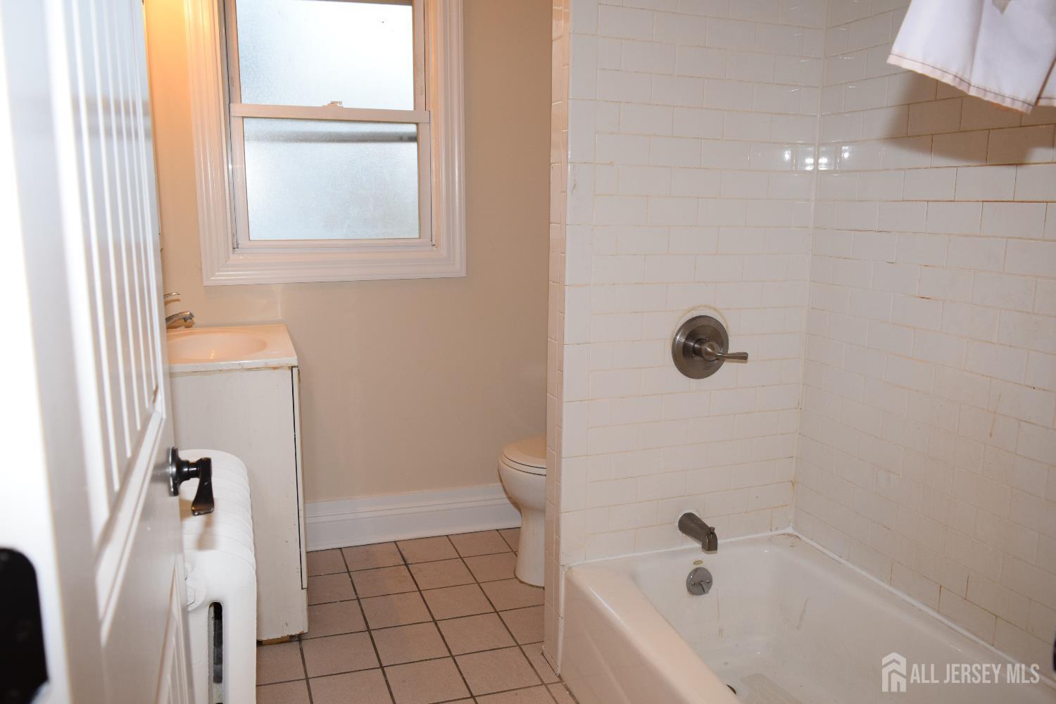 472 Cliff Road, Unit 3 Sewaren, NJ 07077 - Photo 11 of 16 a bathroom with a bathtub a window and a shower