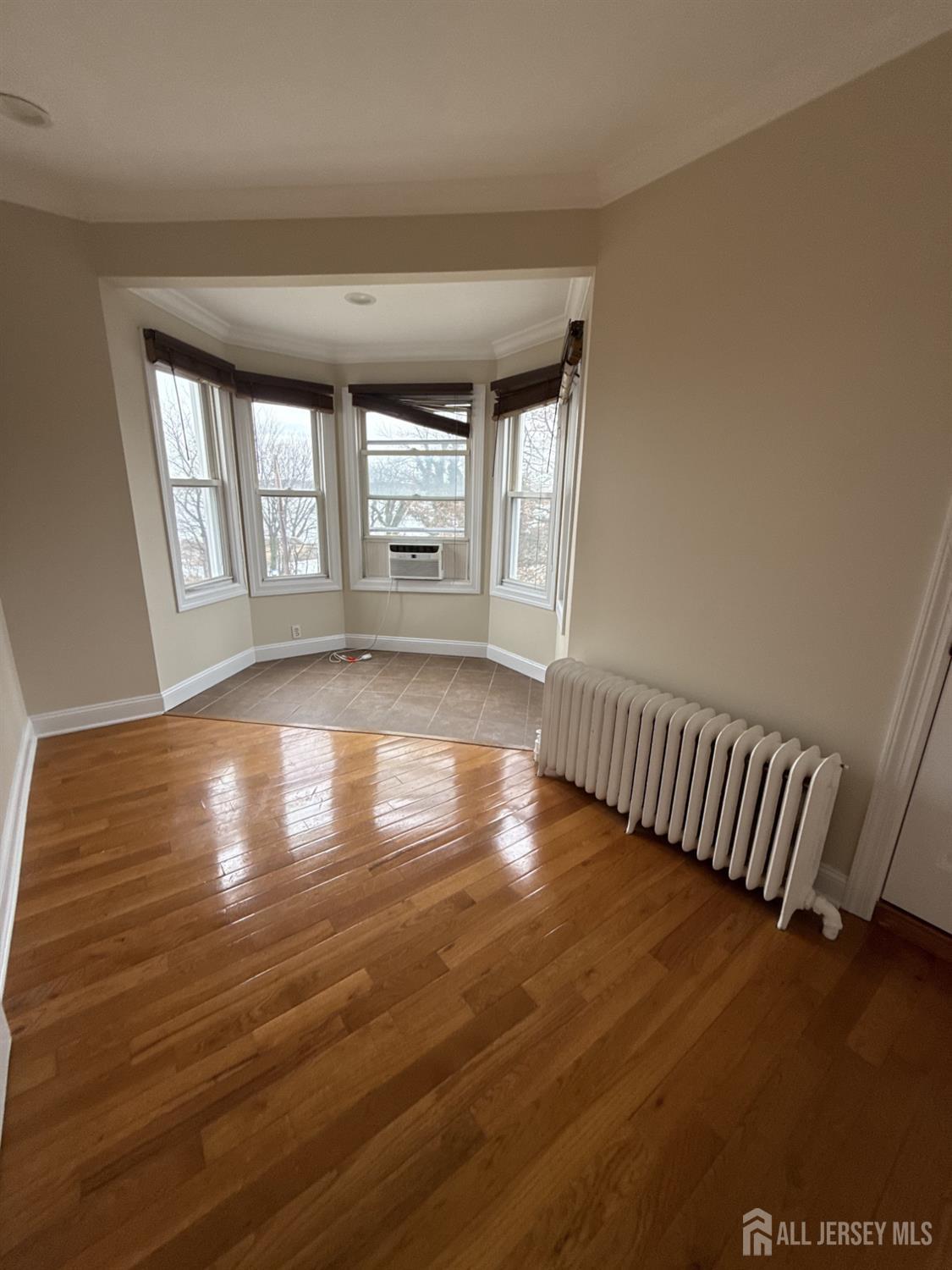 472 Cliff Road, Unit 3 Sewaren, NJ 07077 - Photo 12 of 16 wooden floor in an empty room with a window