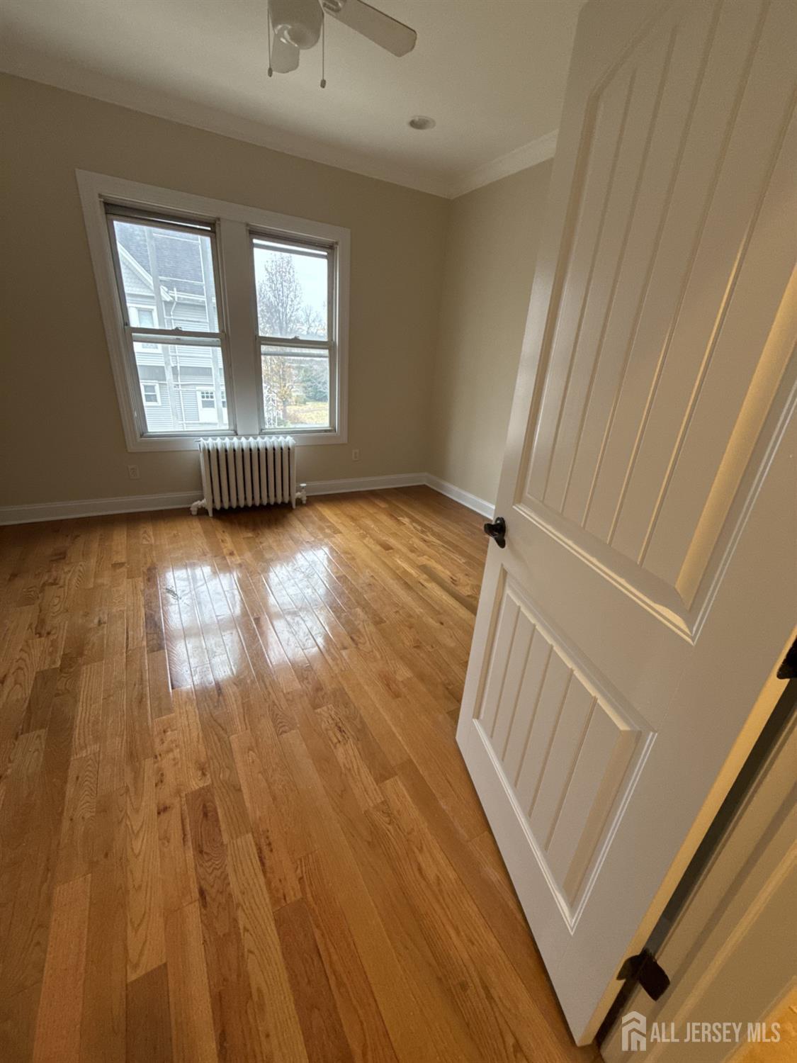 472 Cliff Road, Unit 3 Sewaren, NJ 07077 - Photo 14 of 16 an empty room with wooden floor and windows