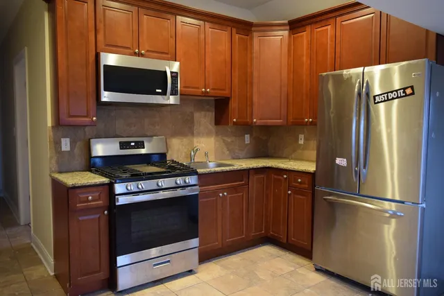 a kitchen with stainless steel appliances granite countertop a refrigerator stove and microwave