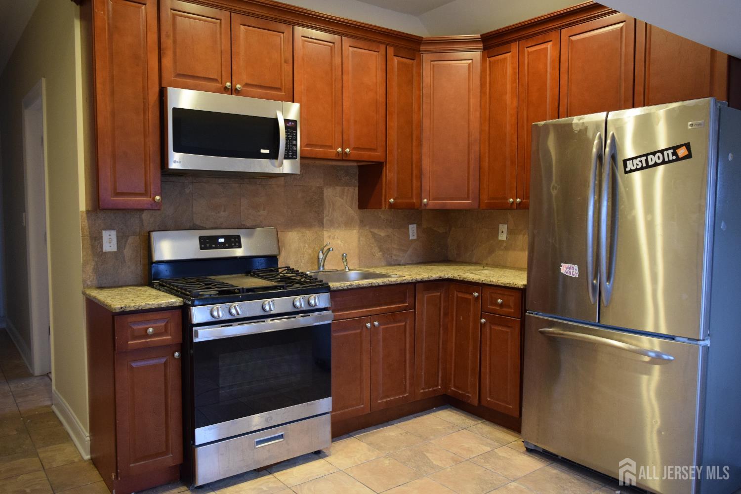 472 Cliff Road, Unit 3 Sewaren, NJ 07077 - Photo 4 of 16 a kitchen with stainless steel appliances granite countertop a refrigerator stove and microwave