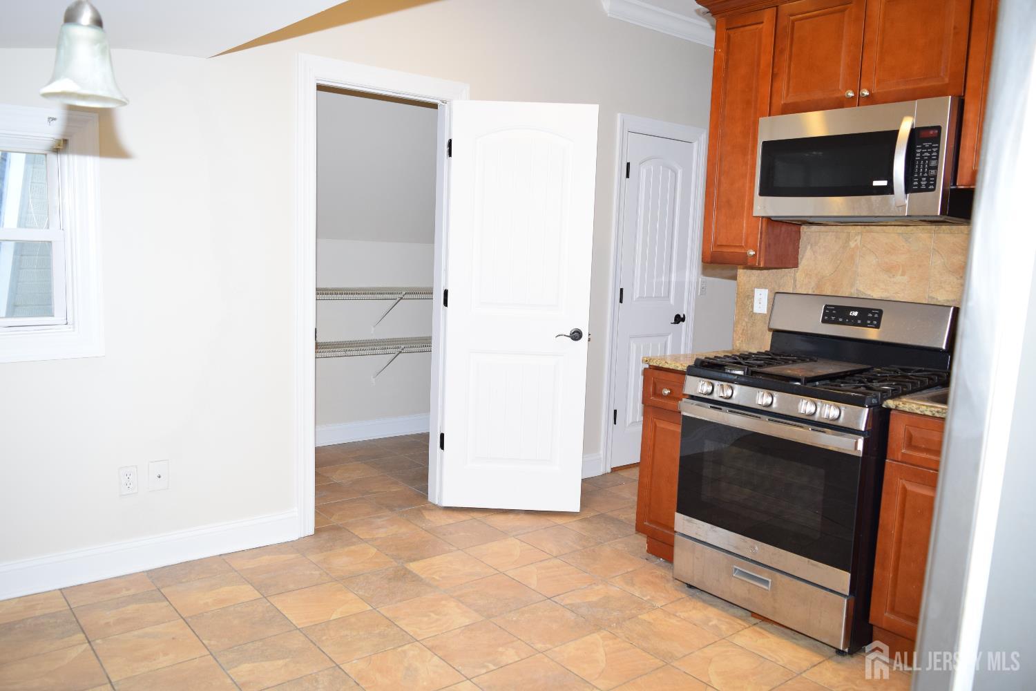472 Cliff Road, Unit 3 Sewaren, NJ 07077 - Photo 5 of 16 a kitchen with a stove and a microwave