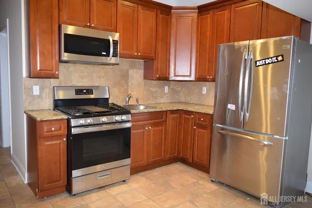 a kitchen with stainless steel appliances granite countertop a refrigerator stove and microwave