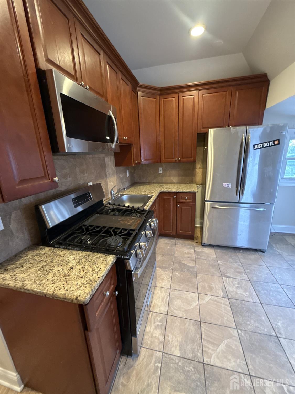 472 Cliff Road, Unit 3 Sewaren, NJ 07077 - Photo 7 of 16 a kitchen with granite countertop a sink a stove top oven and refrigerator