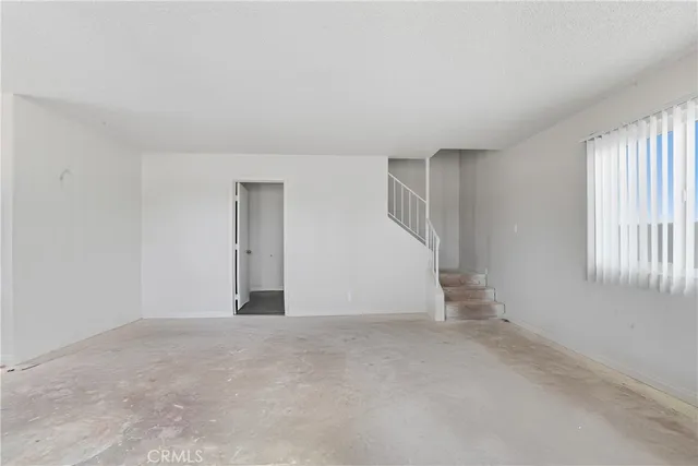 an empty room with windows and cabinet