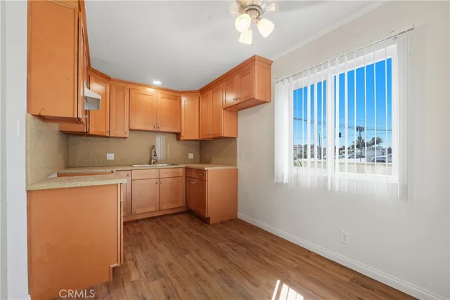 a view of a kitchen with wooden floor and a sink