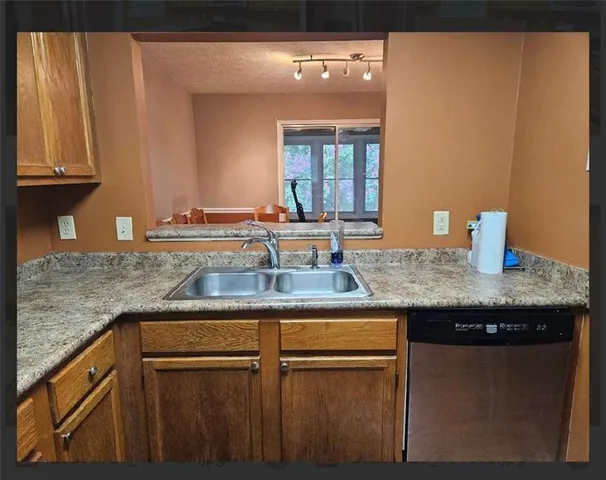 a kitchen with granite countertop stainless steel appliances a stove sink and microwave
