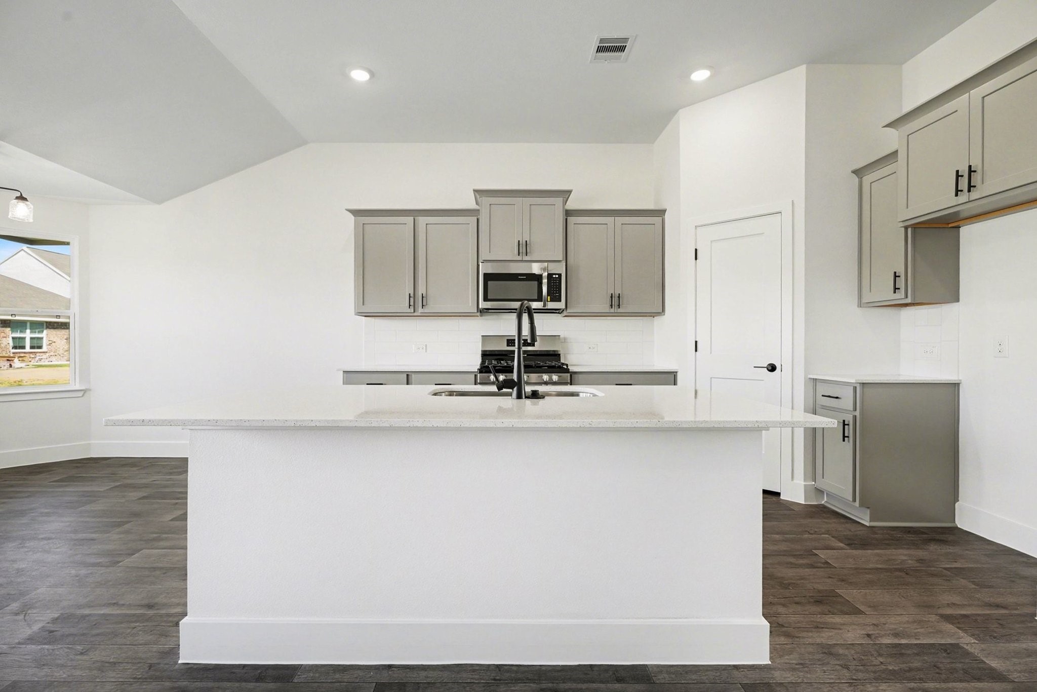 1 Keystone Court Angleton, TX 77515 - Photo 12 of 26 a room with stainless steel appliances granite countertop a sink dishwasher a microwave oven and white countertops with wooden floor