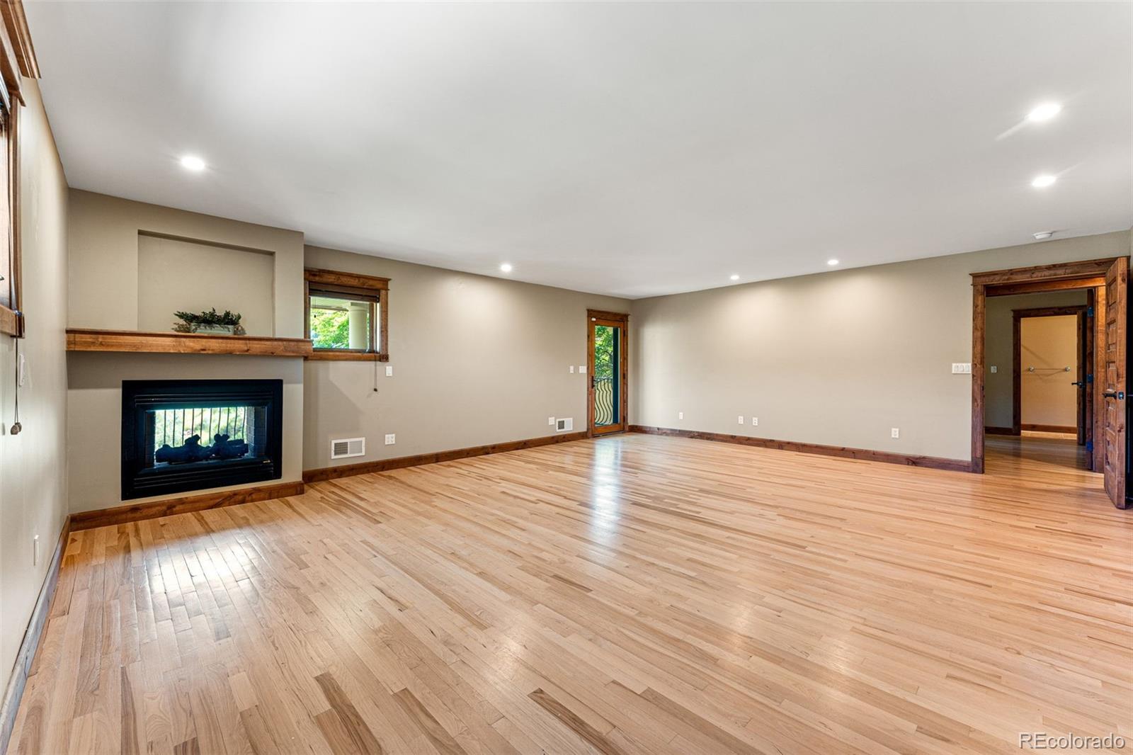 5970 Crestbrook Drive Morrison, CO 80465 - Photo 15 of 34 a view of empty room with wooden floor and fireplace