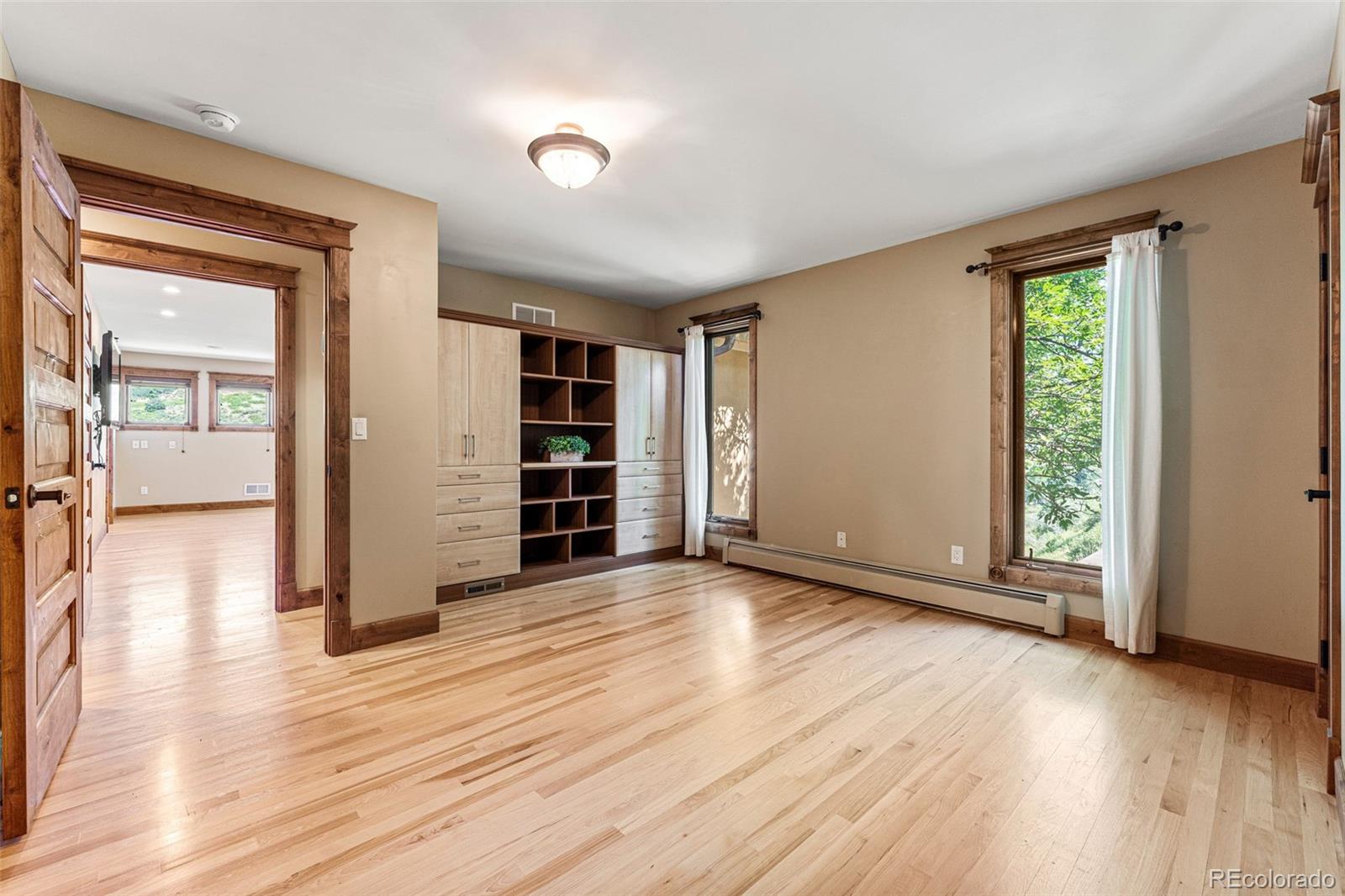 5970 Crestbrook Drive Morrison, CO 80465 - Photo 19 of 34 an empty room with wooden floor and closet
