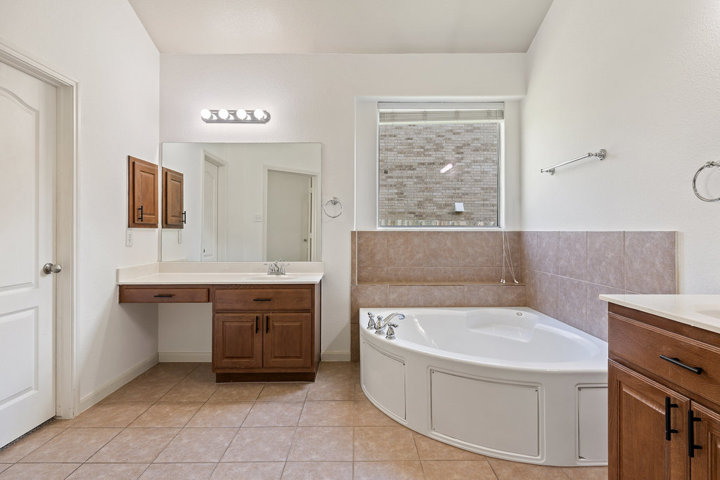2617 Salorn Way Round Rock, TX 78681 - Photo 15 of 40 a bathroom with a tub a sink and a mirror