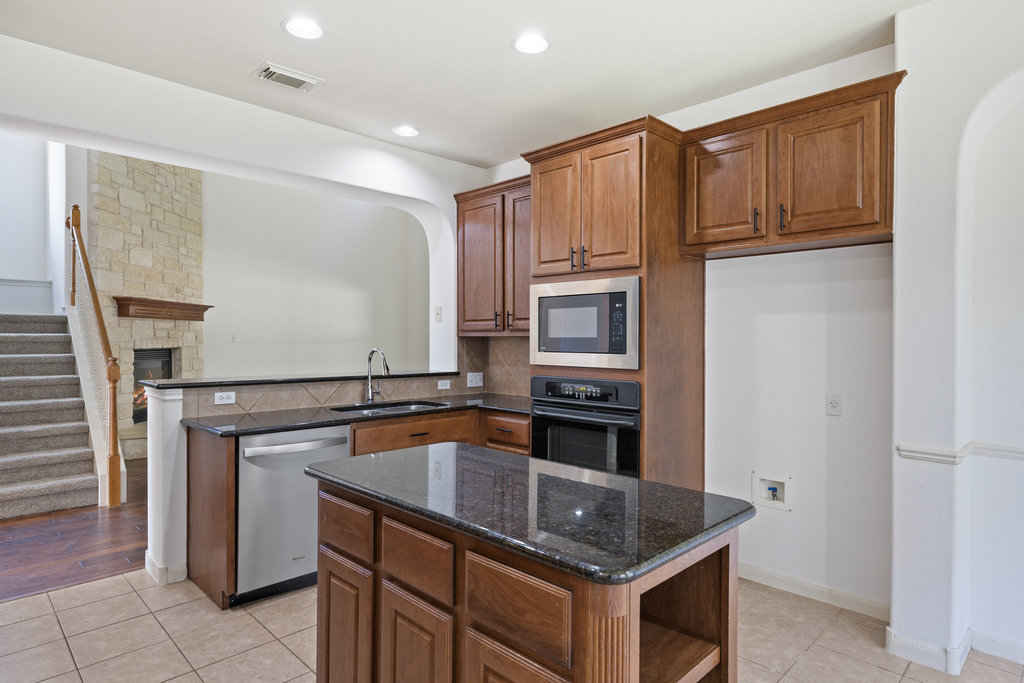 2617 Salorn Way Round Rock, TX 78681 - Photo 24 of 40 a kitchen with stainless steel appliances granite countertop a refrigerator sink and stove