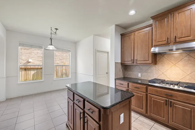a kitchen with stainless steel appliances granite countertop a sink stove and cabinets