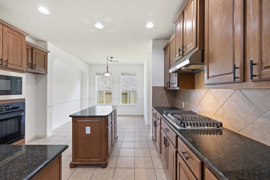 2617 Salorn Way Round Rock, TX 78681 - Photo 26 of 40 a kitchen with stainless steel appliances granite countertop a stove a sink and a refrigerator
