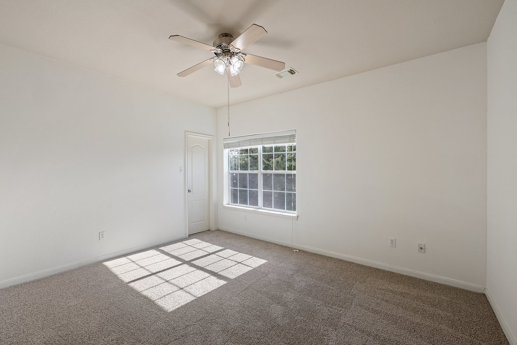 2617 Salorn Way Round Rock, TX 78681 - Photo 30 of 40 an empty room with a chandelier fan and windows