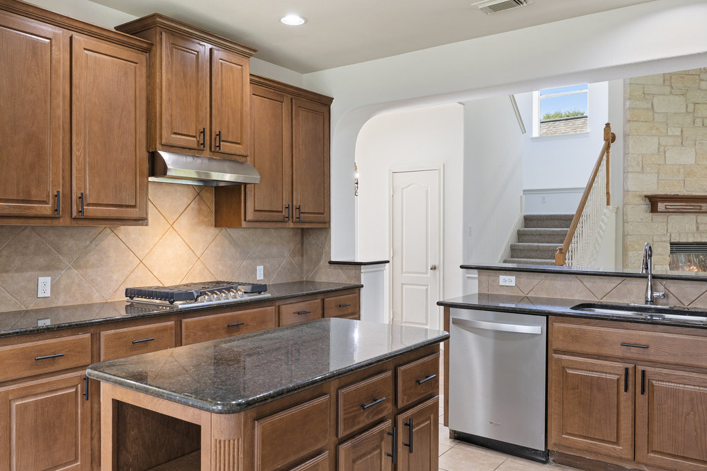 2617 Salorn Way Round Rock, TX 78681 - Photo 7 of 40 a kitchen with stainless steel appliances granite countertop a stove a sink and a white cabinets