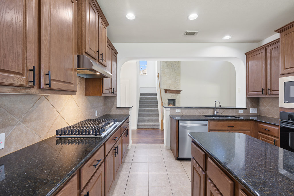 2617 Salorn Way Round Rock, TX 78681 - Photo 8 of 40 a kitchen with stainless steel appliances granite countertop a sink stove and cabinets