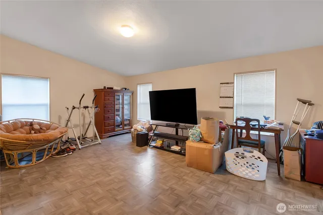 a living room with furniture a flat screen tv and a window