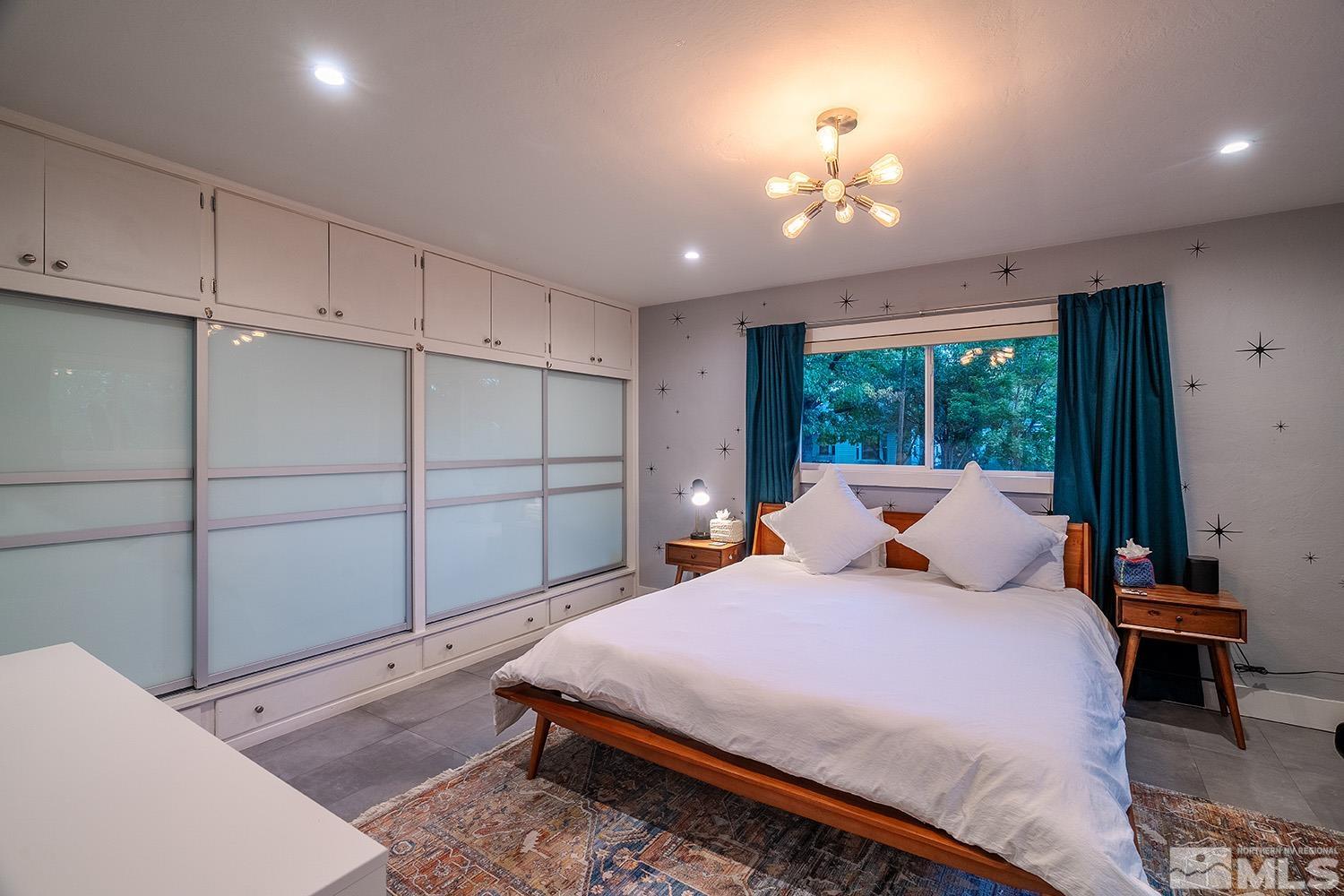 401 Brown Street Reno, NV 89509 - Photo 21 of 40 a bedroom with a bed and a chandelier