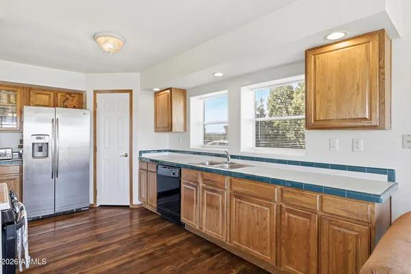 a kitchen with stainless steel appliances granite countertop a refrigerator a sink and wooden cabinets