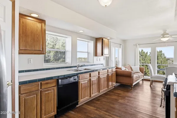 a large kitchen with stainless steel appliances granite countertop a sink dishwasher stove and wooden cabinets
