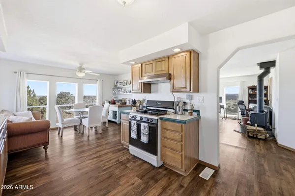 a kitchen with stainless steel appliances granite countertop wooden floors and view living room