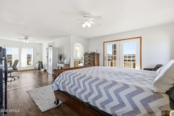 a bed sitting in a spacious bedroom next to a window and a larger closet