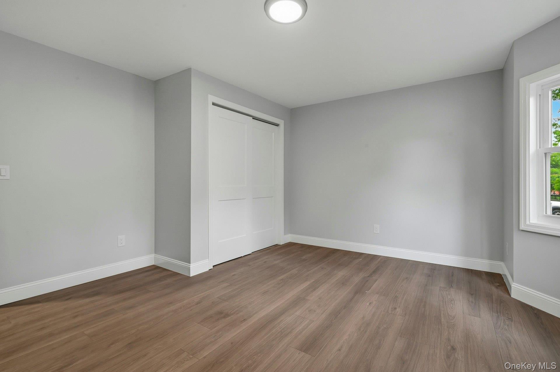 101 Rustic Road Centereach, NY 11720 - Photo 28 of 42 a view of an empty room with wooden floor and a window
